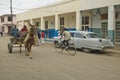 Old cars in Cuban village near the El Rincon driving past old store and villagers