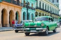 Old cars next to traditional buildings in Old Havan