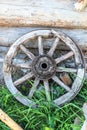 An old cart wheel against the wall of a log house. Royalty Free Stock Photo