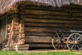 Old cart with wooden wheels against the background of a log house under thatched roof Royalty Free Stock Photo