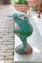 Old carved wooden frog on cement steps