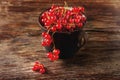 Old cast iron black cup full fresh ripe red currant Royalty Free Stock Photo