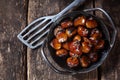 Old cast iron dish full of roasted chestnuts Royalty Free Stock Photo