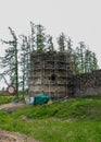 An old castle ruins tower, surrounded by a fence before restoration, Ergeme castle ruins, Latvia