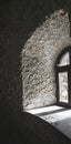 In an old castle, a window shines into a dark room inside Royalty Free Stock Photo