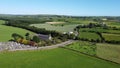 Old Catholic church and cemetery among green farm fields, top view. Picturesque fields in the south of Ireland, landscape. Sacred