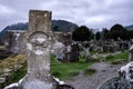 Old catholic granite cross on tombstone with cemetery and tombstones in background, Glendalough, Ireland Royalty Free Stock Photo