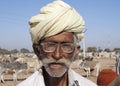 Old cattle farmer with turban and glasses.