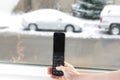 Old cell phone in hand with car in snow Royalty Free Stock Photo