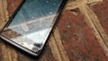 Old cell phone (smartphone) with broken screen on a ground Royalty Free Stock Photo