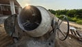 an old cement mixer machine by the pile of sand at the construction site. Royalty Free Stock Photo