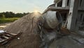 an old cement mixer machine by the pile of sand at the construction site. Royalty Free Stock Photo