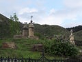 Old cemetery, tombstones, crosses. Mountains and sky. Lilac, gras, tree. Armenia