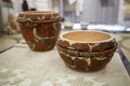 Old ceramic brown pot on a white tablecloth on a table