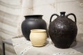 Old ceramic brown pot on a white tablecloth on a table