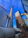 An old ceramic chimney and an old and new flue gas dust collector behind a coal boiler, a grate, against the blue sky Royalty Free Stock Photo