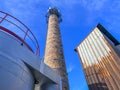 An old ceramic chimney and an old and new flue gas dust collector behind a coal boiler, a grate, against the blue sky Royalty Free Stock Photo