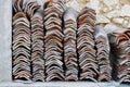 old ceramic tiles for the roof of the house are stacked in rows near the wall for use in repairs. red clay, utilitarian