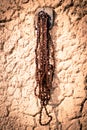 An old chain hanging on the wall of an old house. Royalty Free Stock Photo