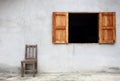 Old chair against old wall with window Royalty Free Stock Photo