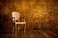 Old chair on a brown wall background. Royalty Free Stock Photo