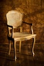 Old chair on a brown wall background. Royalty Free Stock Photo