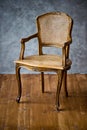 Old chair on a gray wall background. Royalty Free Stock Photo