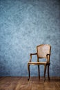 Old chair on a gray wall background. Royalty Free Stock Photo
