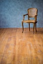 Old chair on a gray wall background. Royalty Free Stock Photo