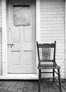 An old chair, old door and a brick wall. Vertical.