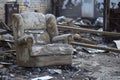 An old chair surrounded by debris in a desolate setting, symbolizing abandonment and decay, Conveying the sense of loss and Royalty Free Stock Photo
