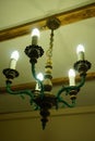 Old chandelier with five lamps hangs on the ceiling with a pre-revolutionary house.