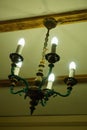 Old chandelier with five lamps hangs on the ceiling with a pre-revolutionary house. Royalty Free Stock Photo