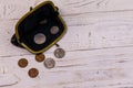 Old change purse with several coins on white wooden background. Concept of poverty or bankruptcy Royalty Free Stock Photo