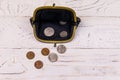 Old change purse with several coins on white wooden background. Concept of poverty or bankruptcy Royalty Free Stock Photo