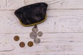 Old change purse with several coins on white wooden background. Concept of poverty or bankruptcy Royalty Free Stock Photo