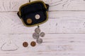 Old change purse with several coins on white wooden background. Concept of poverty or bankruptcy Royalty Free Stock Photo