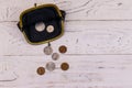 Old change purse with several coins on white wooden background. Concept of poverty or bankruptcy Royalty Free Stock Photo