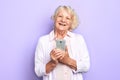 Old cheerful happy woman using her smartphone, isolated light blue background Royalty Free Stock Photo
