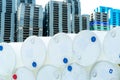 Old chemical barrels. Empty white chemical drums stack on blur industrial plastic pallets. Toxic waste warehouse. Hazard chemical