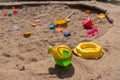 an old children's outdoor sandbox with a children's watering can in the foreground and a bunch of forgotten toys Royalty Free Stock Photo