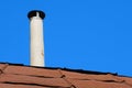 Old chimney of asbestos pipe over a rusty metal roof Royalty Free Stock Photo