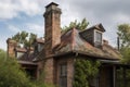 old chimney, with the rustic charm of exposed brick and weathered siding, on modern metal roof Royalty Free Stock Photo