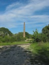 Old chimney stack between green bushes under a blue sky Royalty Free Stock Photo