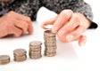 An old Chinese lady is stacking a row of dollar coins