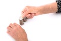 An old Chinese lady is stacking a row of dollar coins