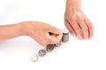 An old Chinese lady is stacking a row of dollar coins