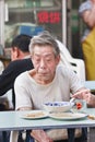 Old Chinese man eats in a neighborhood restaurant, Beijing, China