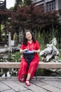 Old Chinese woman in red beating a long drum Royalty Free Stock Photo