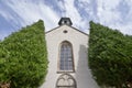 Old Christian church with a cross and 2 big thujas in the European city of Baden Baden, Germany Royalty Free Stock Photo